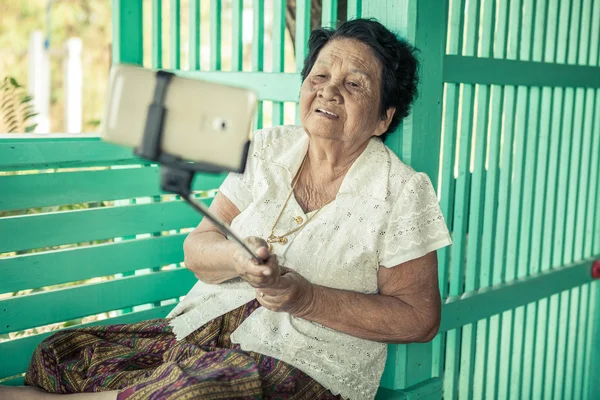 Счастливая пожилая женщина позирует для селфи — стоковое фото