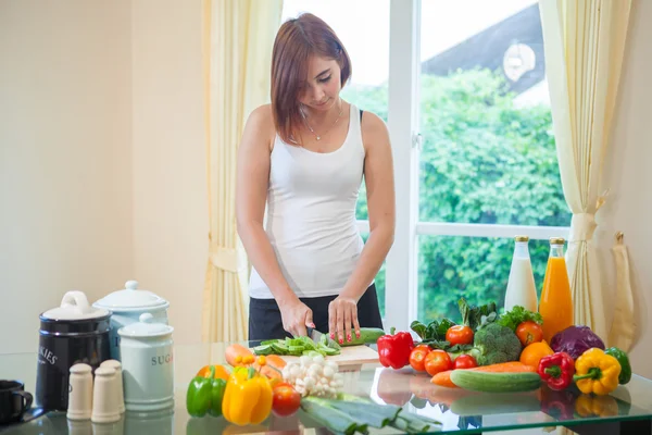 Happy woman cooking vegetables green salad — Stock Photo, Image