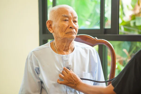 Médico amigável cuidar homem idoso interior — Fotografia de Stock