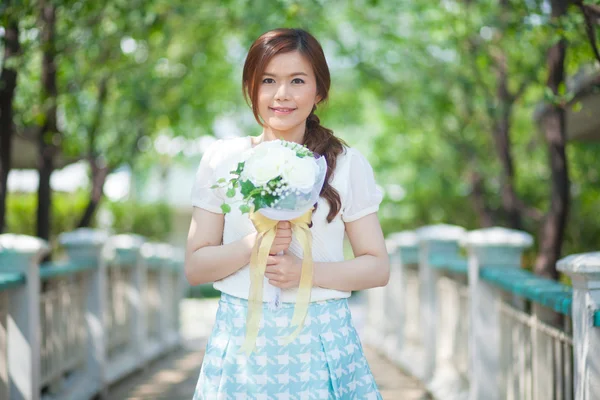 Jovem asiático bonito mulher cheirando flores brancas — Fotografia de Stock