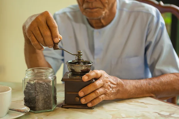 Asian senior man with vintage coffee grinder — Stock Photo, Image