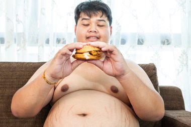 Ffat adam yeme hamburger oturmuş