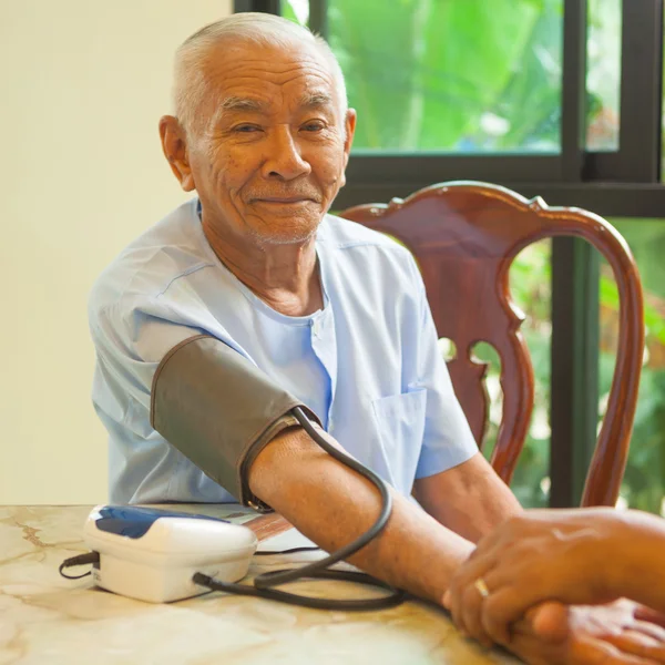 Lekarz Mierzenie ciśnienia krwi pacjenta płci męskiej — Zdjęcie stockowe