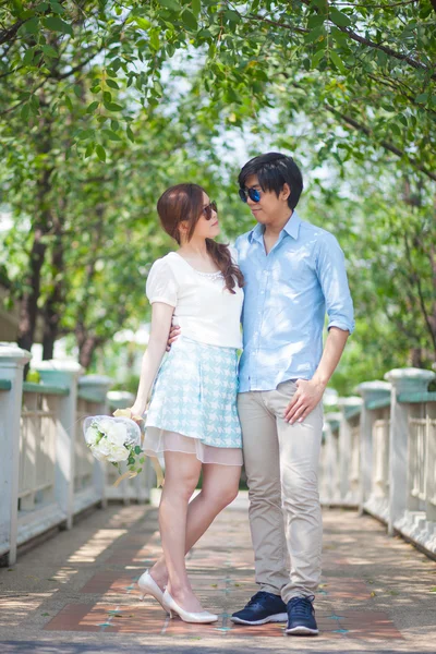 Loving asian couple under tree in the park — Stock Photo, Image