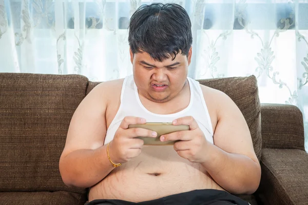 Fat asian man play game with his smartphone — Stock Photo, Image