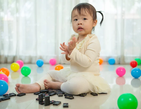 Malá dívka si hraje s černé domino — Stock fotografie