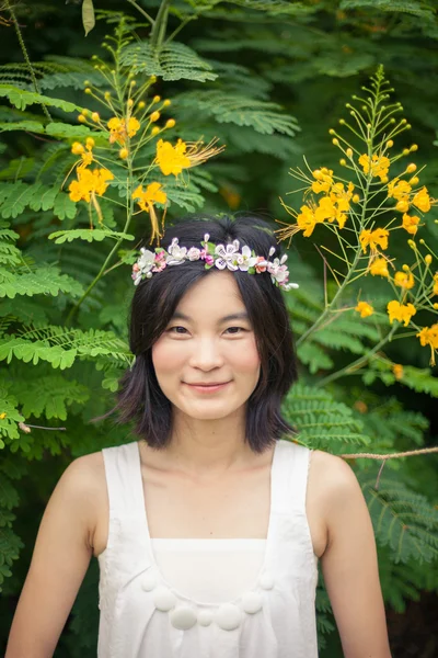 Jonge vrouw met een kroon van bloemen — Stockfoto