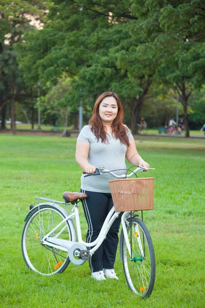 Gärna fet kvinna poserar med cykel — Stockfoto