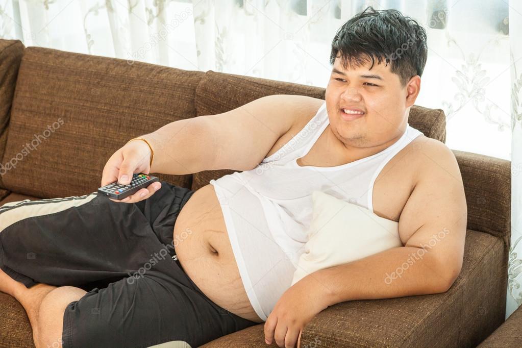 Overweight guy sitting on the couch to watch some TV