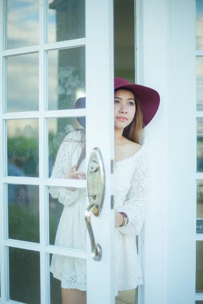 Sad asian vintage woman looking out the door — Zdjęcie stockowe