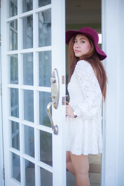 Sad asian vintage woman looking out the door — Stockfoto