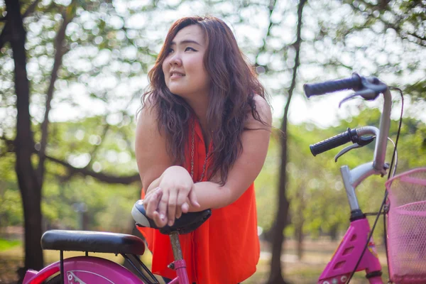 Heureuse femme grasse posant avec vélo — Photo