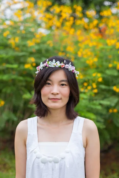 Jonge vrouw met een kroon van bloemen — Stockfoto