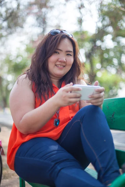 Šťastný tukové žena pomocí mobilního telefonu — Stock fotografie