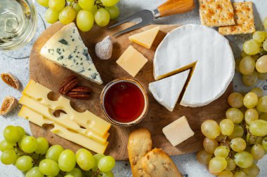 Tahta tabakta peynir tadı. Şarap ve romantik randevu için yemek, açık beton arka planda peynir şarküteri. Üst görünüm.