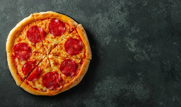 Leckere Pfefferoni-Pizza und Kochzutaten Tomaten Basilikum auf schwarzem Betongrund. Blick von oben auf die Chili-Pizza. Mit Kopierraum für Text. Flach lag er. Banner — Stockfoto