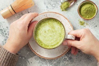 Bir fincan Matcha Green Tea, kadınların elinde. Üst Manzara. düz yat.