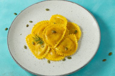 Hafif beton arka planda tereyağlı ev yapımı Balkabağı Ravioli. Üst görünüm.