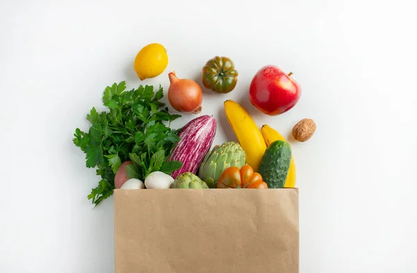 Healthy food background. Healthy vegan vegetarian food in paper bag vegetables and fruits on white, copy space. Shopping food supermarket and clean vegan eating concept