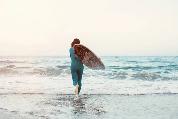 砂浜でボードで歩くサーファーの女の子 女性をサーフィン ビーチで美しい若い女性 ウォータースポーツ 健康的なアクティブライフスタイル 夏休み エクストリームスポーツ — ストック写真