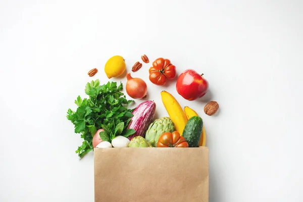 Healthy food background. Healthy vegan vegetarian food in paper bag vegetables and fruits on white, copy space. Shopping food supermarket and clean vegan eating concept.