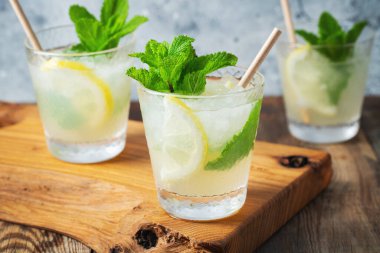 İki bardak limonata ya da naneli mojito kokteyli soğuk, ferahlatıcı içecek ya da buzlu, mavi arka planda buzlu içecek.