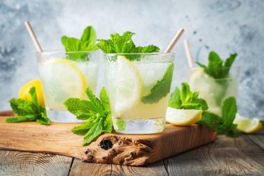 İki bardak limonata ya da naneli mojito kokteyli soğuk, ferahlatıcı içecek ya da buzlu, mavi arka planda buzlu içecek.
