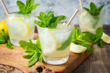 İki bardak limonata ya da naneli mojito kokteyli soğuk, ferahlatıcı içecek ya da buzlu, mavi arka planda buzlu içecek.