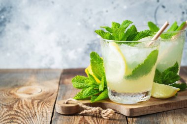 İki bardak limonata ya da naneli mojito kokteyli soğuk, ferahlatıcı içecek ya da buzlu, mavi arka planda buzlu içecek. Boşluğu kopyala