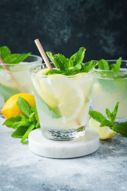 İki bardak limonata ya da naneli mojito kokteyli soğuk, ferahlatıcı içecek ya da buzlu, mavi arka planda buzlu içecek.