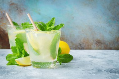 İki bardak limonata ya da naneli mojito kokteyli soğuk, ferahlatıcı içecek ya da buzlu, mavi arka planda buzlu içecek. Boşluğu kopyala