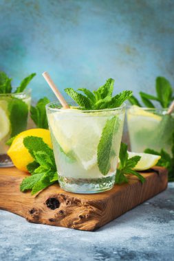 İki bardak limonata ya da naneli mojito kokteyli soğuk, ferahlatıcı içecek ya da buzlu, mavi arka planda buzlu içecek. Boşluğu kopyala