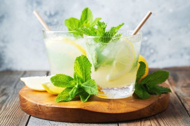 İki bardak limonata ya da naneli mojito kokteyli soğuk, ferahlatıcı içecek ya da buzlu, mavi arka planda buzlu içecek..