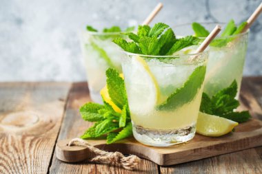 İki bardak limonata ya da naneli mojito kokteyli soğuk, ferahlatıcı içecek ya da buzlu, mavi arka planda buzlu içecek. Boşluğu kopyala