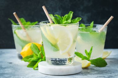 İki bardak limonata ya da naneli mojito kokteyli soğuk, ferahlatıcı içecek ya da buzlu, mavi arka planda buzlu içecek.