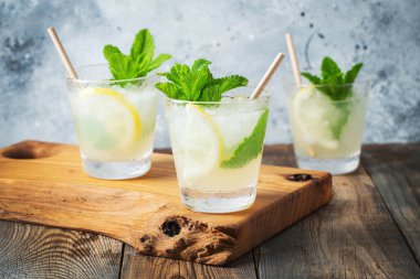 İki bardak limonata ya da naneli mojito kokteyli soğuk, ferahlatıcı içecek ya da buzlu, mavi arka planda buzlu içecek.