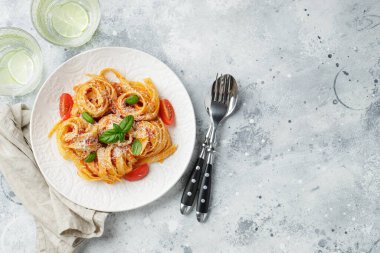 Lezzetli iştah açıcı klasik İtalyan tagliatelle makarnası domates soslu, peynirli parmesan peyniri ve tabakta fesleğen. Yukarıdan bak, yatay. Kopyalama alanı olan üst görünüm.