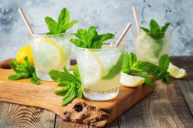 İki bardak limonata ya da naneli mojito kokteyli soğuk, ferahlatıcı içecek ya da buzlu, mavi arka planda buzlu içecek..