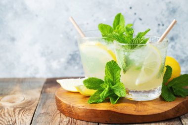 İki bardak limonata ya da naneli mojito kokteyli soğuk, ferahlatıcı içecek ya da buzlu, mavi arka planda buzlu içecek. Boşluğu kopyala.
