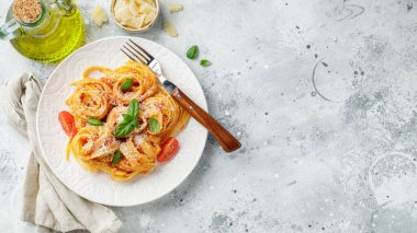 Lezzetli iştah açıcı klasik İtalyan tagliatelle makarnası domates soslu, peynirli parmesan peyniri ve tabakta fesleğen. Yukarıdan bak, yatay. Kopyalama alanı olan üst görünüm.