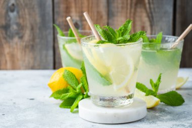 İki bardak limonata ya da naneli mojito kokteyli soğuk, ferahlatıcı içecek ya da buzlu, mavi arka planda buzlu içecek. Boşluğu kopyala
