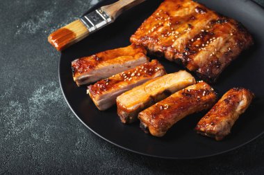 Barbekü soslu bir tabakta servis edilen sıcak ızgara pirzola. Üst Manzara. Boşluğu kopyala.