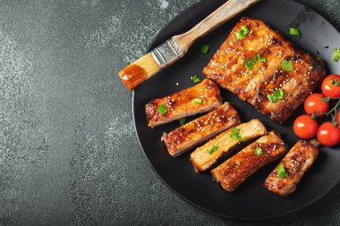 Barbekü soslu bir tabakta servis edilen sıcak ızgara pirzola. Üst Manzara. Boşluğu kopyala.