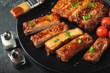 Barbekü soslu bir tabakta servis edilen sıcak ızgara pirzola. Üst Manzara. Boşluğu kopyala.