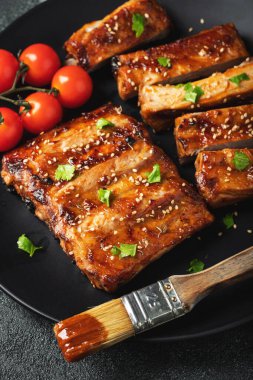 Barbekü soslu bir tabakta servis edilen sıcak ızgara pirzola. Üst Manzara. Boşluğu kopyala.