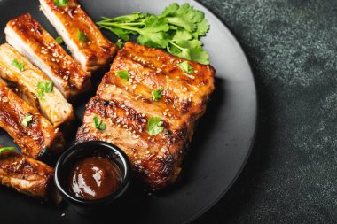 Barbekü soslu bir tabakta servis edilen sıcak ızgara pirzola. Üst Manzara. Boşluğu kopyala.