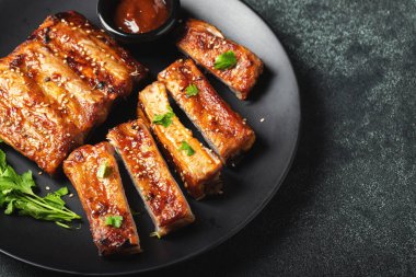 Barbekü soslu bir tabakta servis edilen sıcak ızgara pirzola. Üst Manzara. Boşluğu kopyala.