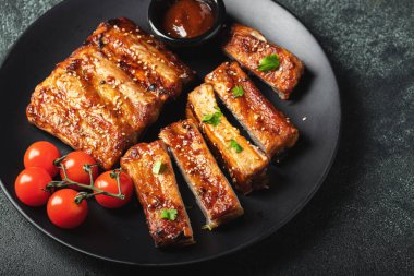 Barbekü soslu bir tabakta servis edilen sıcak ızgara pirzola. Üst Manzara. Boşluğu kopyala.