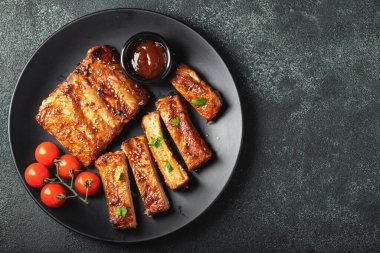 Barbekü soslu bir tabakta servis edilen sıcak ızgara pirzola. Üst Manzara. Boşluğu kopyala.