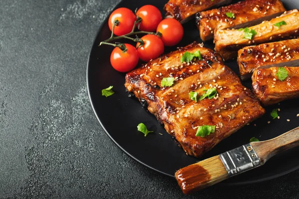 Barbekü soslu bir tabakta servis edilen sıcak ızgara pirzola. Üst Manzara. Boşluğu kopyala.